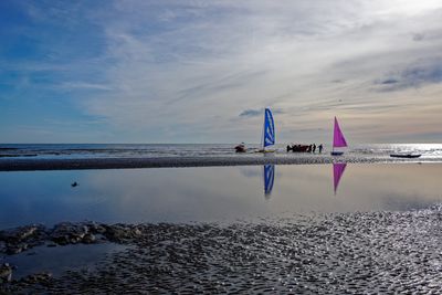 Low tide Bexhill on Sea. Distant figures hauling vessels
